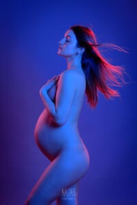 foto di donna in gravidanza in studio con luci colorate