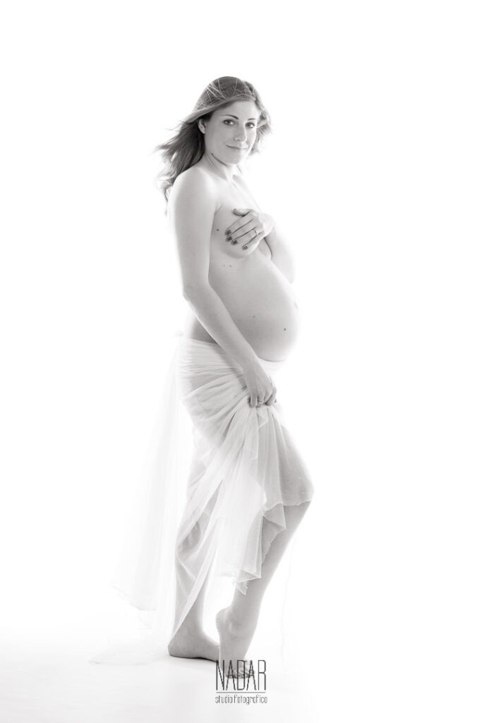 donna in gravidanza durante servizio fotografico con fondo bianco