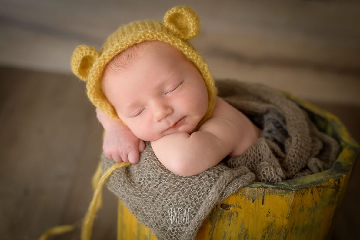 neonato che dorme dentro mastello durante servizio fotografico