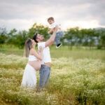 Famiglia felice in natura con bambino che gioca all’aperto